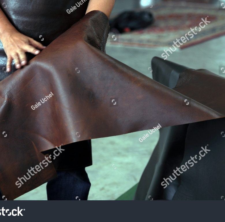 stock-photo-professional-crafter-choosing-brown-cow-leather-for-making-leather-items-691610656